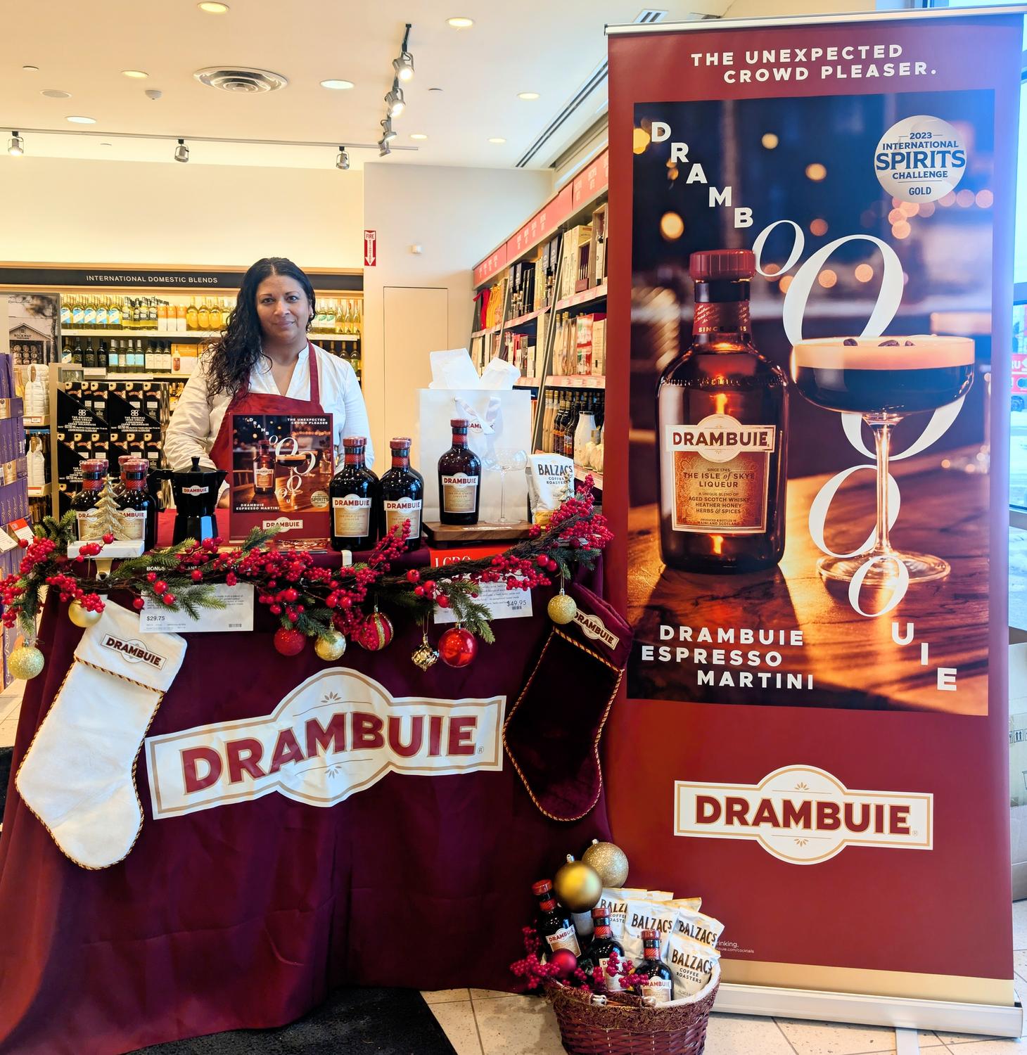 Brand ambassador at a Glenlivet whisky sampling table, showcasing premium whisky bottles and branded materials in a sleek setup.