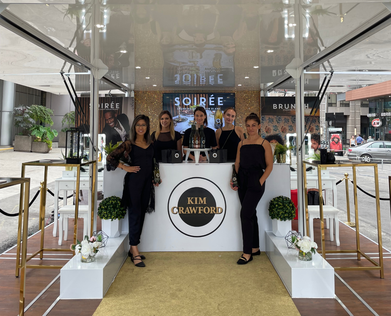 Group of brand ambassadors posing in front of a stylish Kim Crawford booth at TIFF, promoting premium wines at the event.